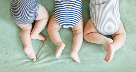 Newborn triplets lie on a stomach on a blanket - 346350622