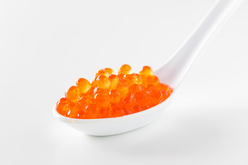 Close up view of a ceramic spoon filled with Salmon Roe.