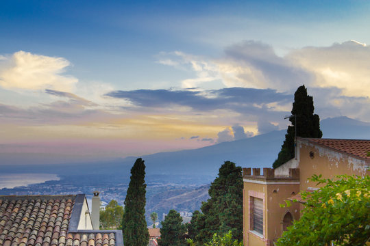 Smoke of Mt. Etna mixes with sunset sky over Sicily, Italy.