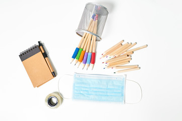 School objects next to antiviral mask
