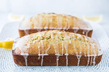 A close up of two glazed lemon poppy seed loaves on a tray.