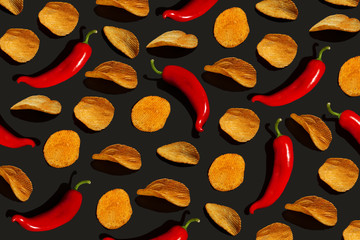 Chips and red pepper on a black background. Modern pattern