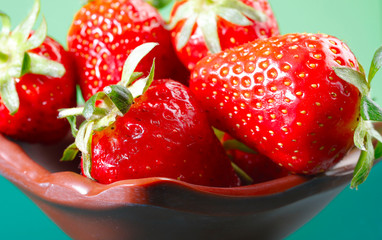 Fruit background. Close-up red strawberry in a brown plate. Strawberry berries texture. Beautiful close-up berries. Horizontal, close-up, nobody, side view. Concept of healthy eating and agriculture.