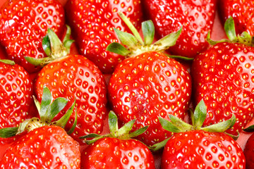 Fruit background. Background of red strawberries. The texture of strawberries. Beautiful berries close-up. Horizontal, close-up, nobody. The concept of agriculture and healthy nutrition.