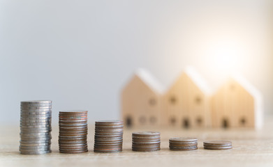 Money savings concepts. Stacked coins with blur wooden house in meaning about saving money to buy a...