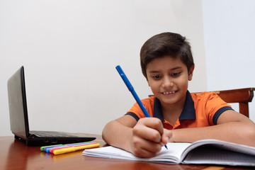 Child using a laptop during isolation from the coronavirus outbreak. Distance education, home education, online education 