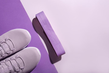 New purple sneakers and strap on colorful background with copy space. Healthy lifestyle concept.