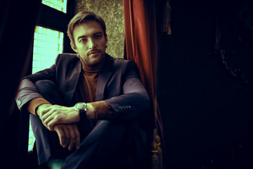 young man sitting on windowsill