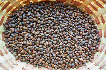 Pine nuts lie in a wicker basket