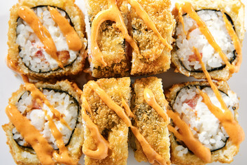Shrimp rolls with cream cheese, tomatoes and Spicy sauce on white background top view