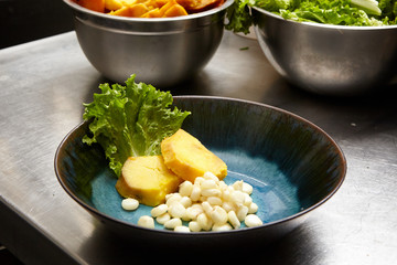 Boiled corn lettuce and sweet potato on a blue plate