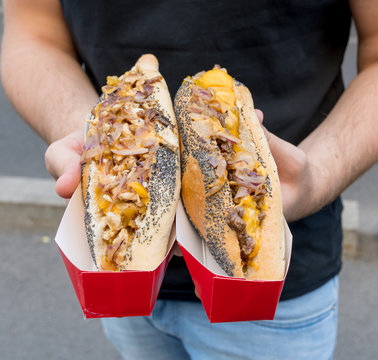 Sausage hot dog during fast food festival event. Outside catering or outdoor party grab and go dish