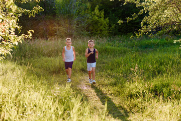 Two gay boys run through the park in the windlight in the summer