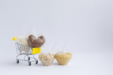 various groats in a grocery cart on a white background
