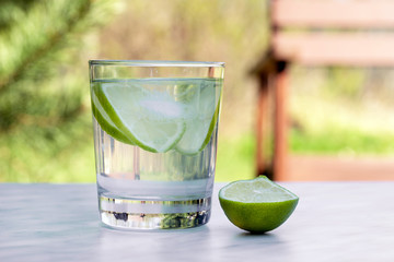 lime coctail with ice in glass, summer background