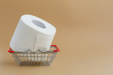 roll of white toilet paper on a brown background and a grocery basket