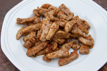 Fried pork with garlic and pepper on a white plate