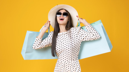 Asian pretty young woman  on yellow colour background. She smiling and  happy shopping bags. she...
