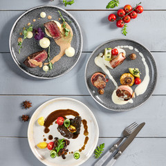 Hot meals, meat appetizers in ceramic plates top view