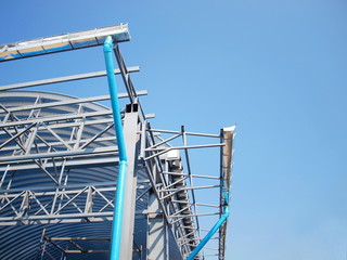 Pipes and rainwater gutters with metal frames on the dome being built On the blue sky background. Selective focus