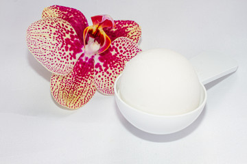ice cream vanilla in a spoon and orchid flower