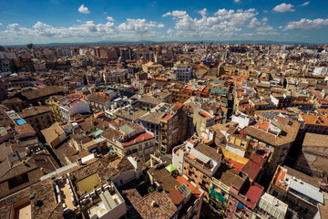 Scenic view from the height of the cathedral in the center of Valencia. Many tile roofs on a background of bright clouds. Typical landscape of Spain
