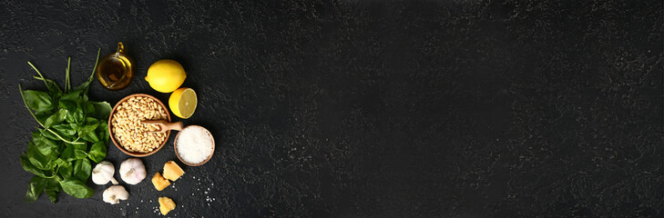 Ingredients for pesto sauce on dark background with space for text