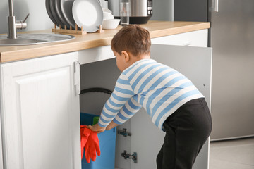 Little boy playing with cleaning supplies at home