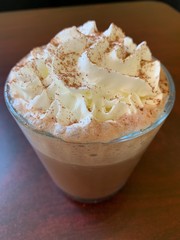 A glass white chocolate mocha with whipped cream
