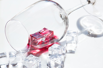 glass of red wine and pieces of ice.