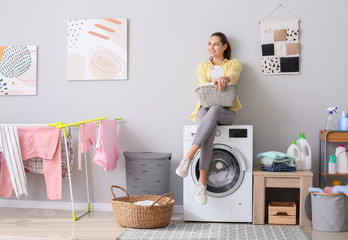 Young woman doing laundry in bathroom