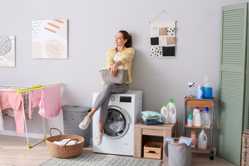 Young woman doing laundry in bathroom