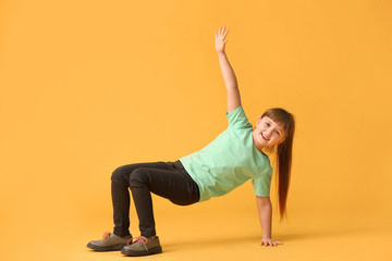 Cute little girl dancing against color background