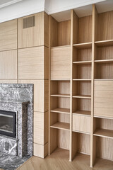 Wooden bookcases and wall panels around the fireplace