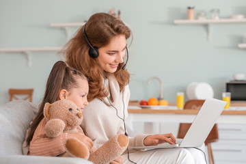 Working mother with little daughter at home