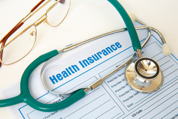 Health insurance with insurance claim form and stethoscope.
