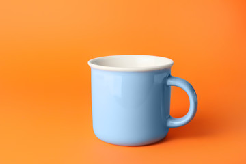 Blank cup on color background