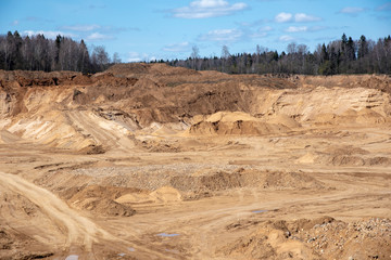 Sand deep quarry under a blue cloudy sky.