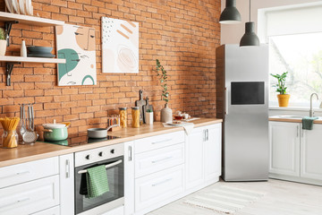 Stylish interior of modern kitchen with big refrigerator