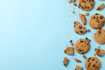 Tasty chocolate chip cookies on blue background, top view