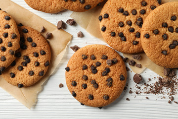Composition with chip cookies and chocolate on white wooden background