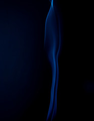 a thin stream of blue smoke on a black background