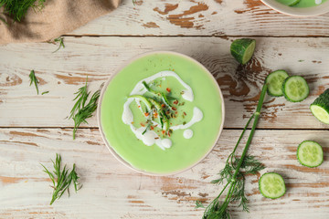 Bowl with cold cucumber soup on table