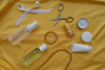 Set of cosmetics for makeup and manicure and jewelry on a yellow background. The view from the top.