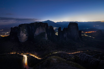 Meteora rocks at evening night time with light from city