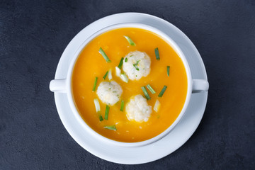 Pumpkin cream soup with rice dumplings on a black concrete background with copy space. Healthy eating. Flat lay composition