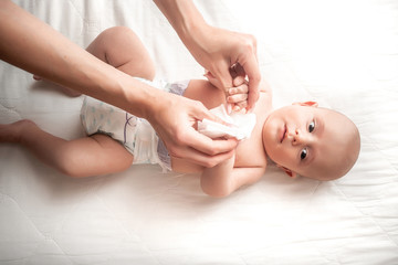 Concept Hygiene cleaning wipe, pure, clean. Mother cleaning up and wipes body and leg baby by wet...