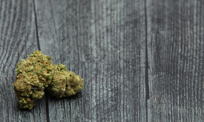 Large Marijuana Bud Isolated on Wood Table