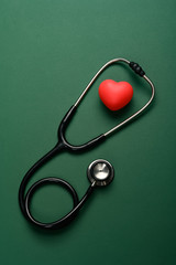 top view heart and stethoscope on a green background