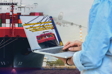 Fototapeta premium Worker with computer notebook prow container ship alongside in port, view of commercial Logistic import export container stacking on vessel and a plane background.
